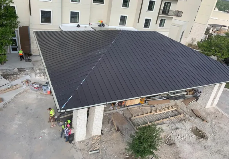 Metal roofing installation team working on a commercial building in Aledo